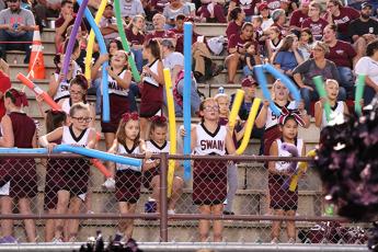 Fans at Swain football game including cheerleaders and fans with pool noodles