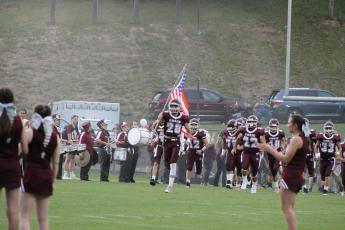 The Maroon Devils got hyped up as fans, cheerleaders, and the marching band lined the field as Maroon Devil Cole Wikle led the charge carrying an American flag as his teammates bust through the banner onto the field.