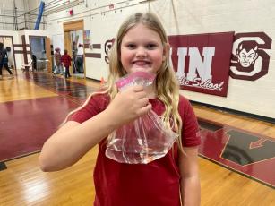 Hollyn Rutkosky grins ear to ear as she holds a fish she won from throwing a ping pong ball into a fish bowl at the Fall Festival