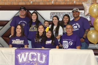 Swain senior Amaya Hicks signs to run at WCU. She's surrounded by family at a ceremony held last week at Swain.