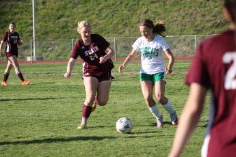 Anna Gray vies to get the ball as an opposing Bobcat player closes in, too.